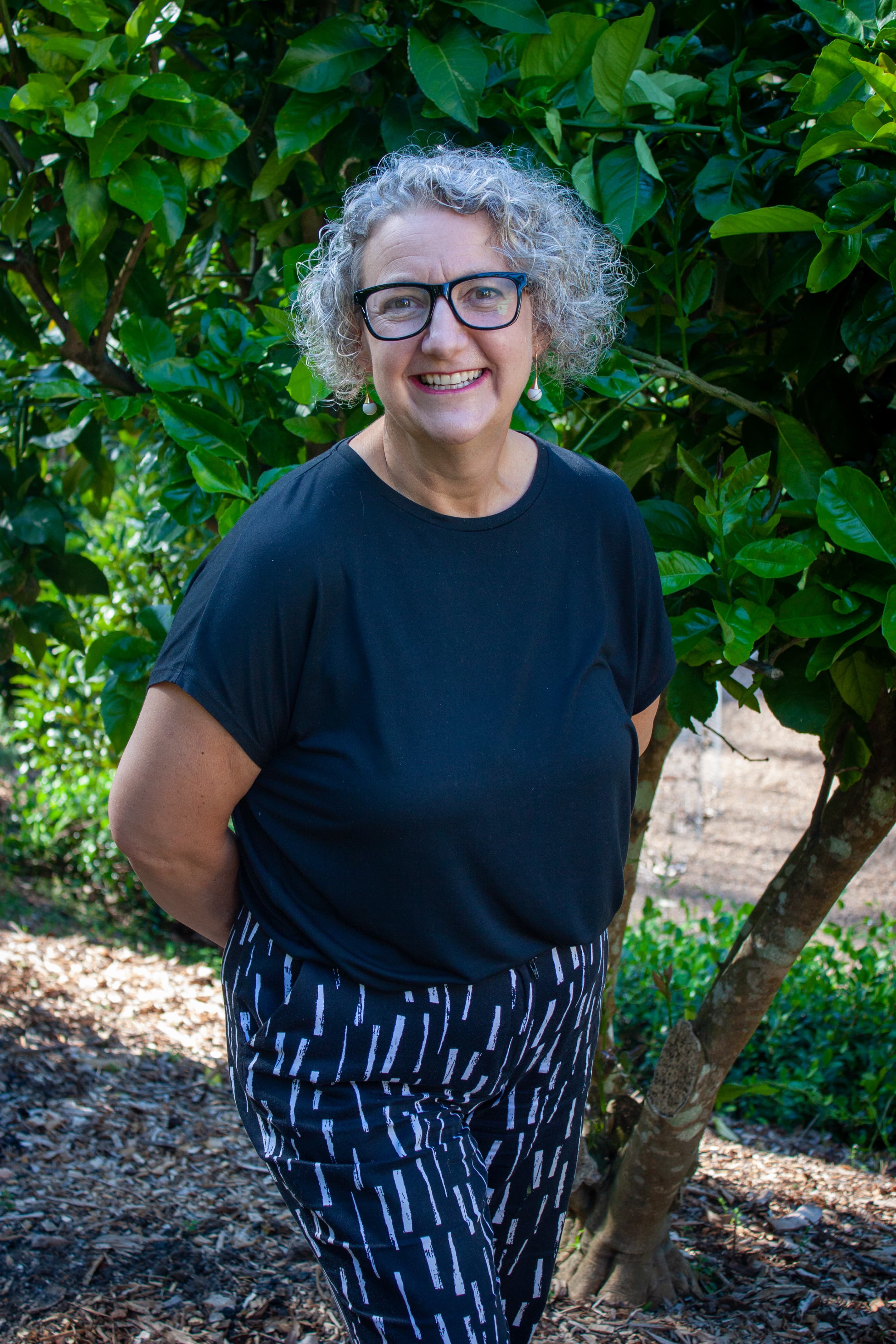 Gill McLaren, creator of the Think.Plan.Live. methodology, smiling in a garden.